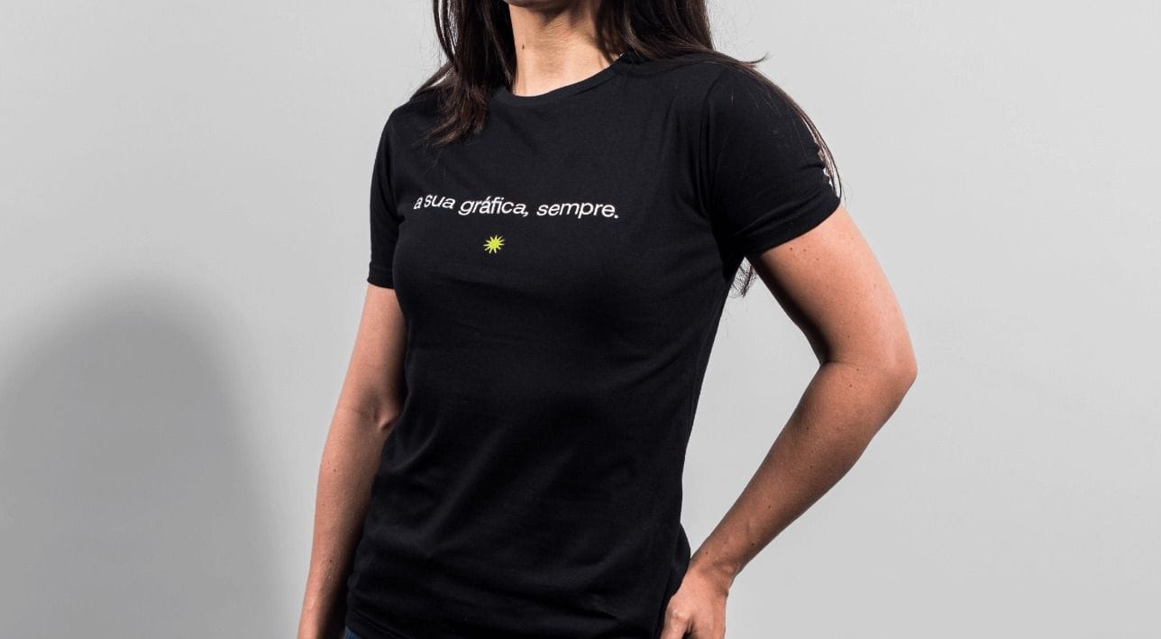Camiseta personalizada preta com estampa minimalista, modelo feminino vestindo peça promocional ideal para marcas, eventos e uniformes.