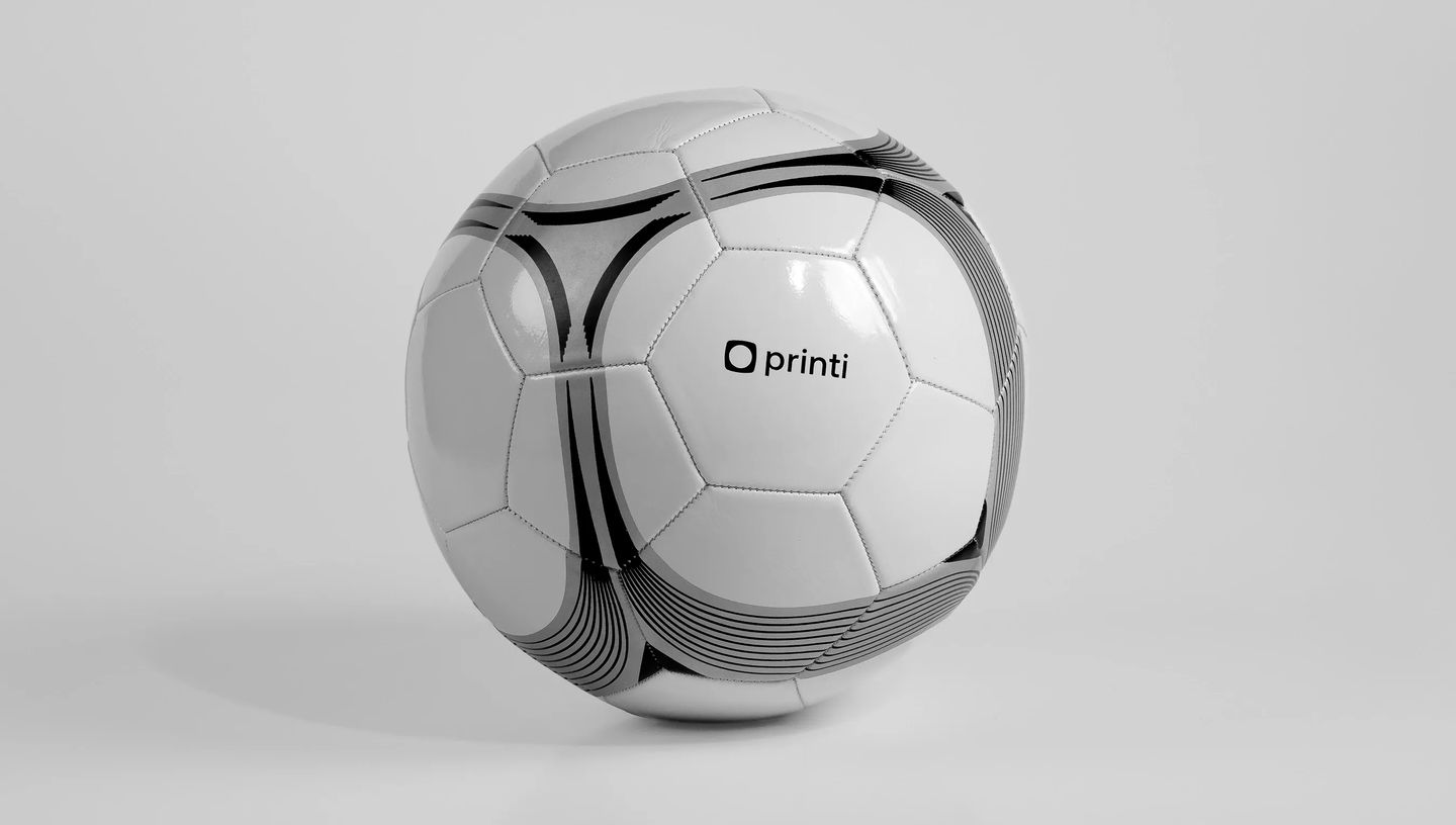 Bola de futebol branca personalizada com grafismos em preto e logotipo Printi centralizado.