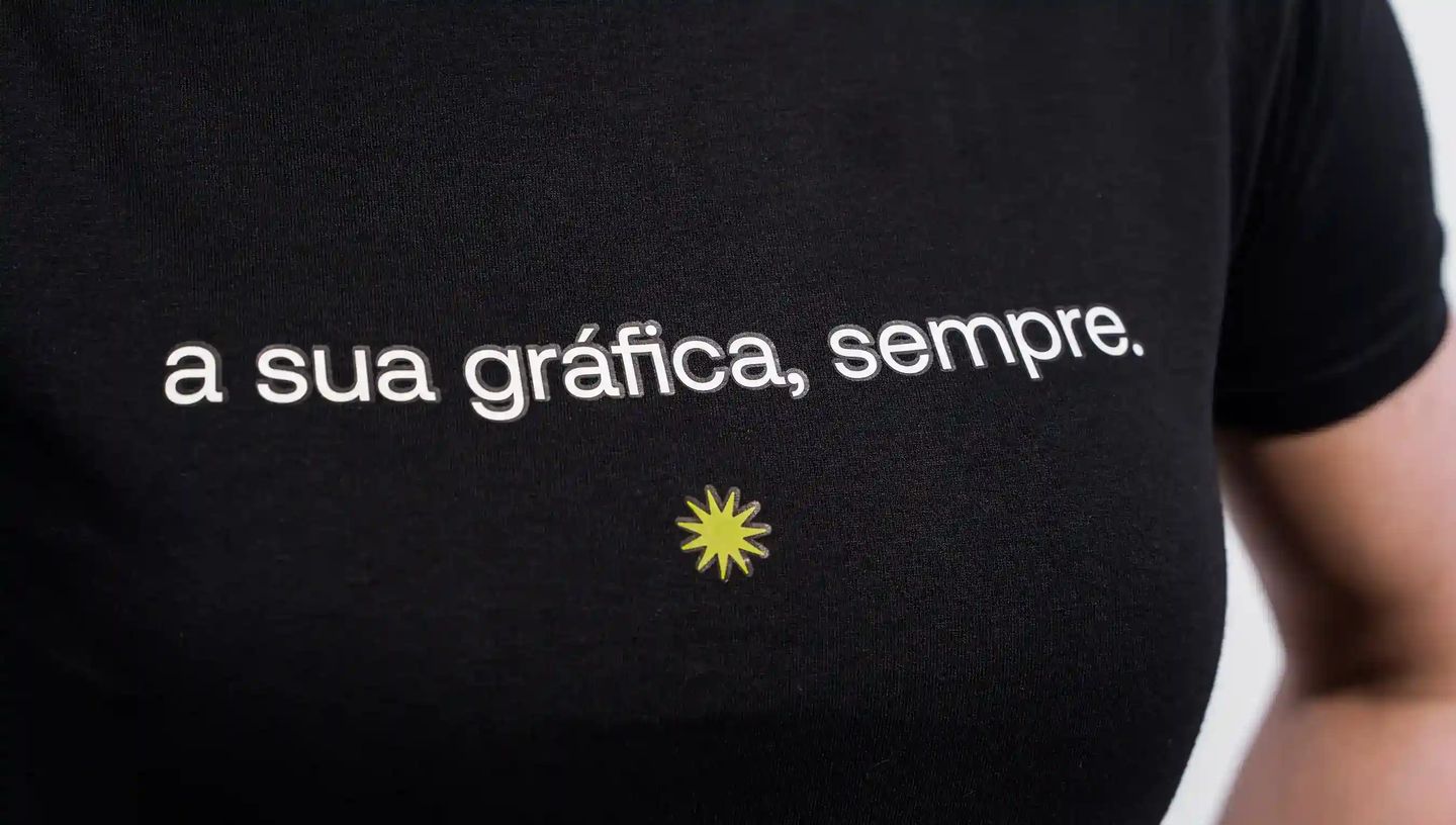 Camiseta personalizada preta com frase estampada no peito, ideal para uniformes e brindes corporativos.