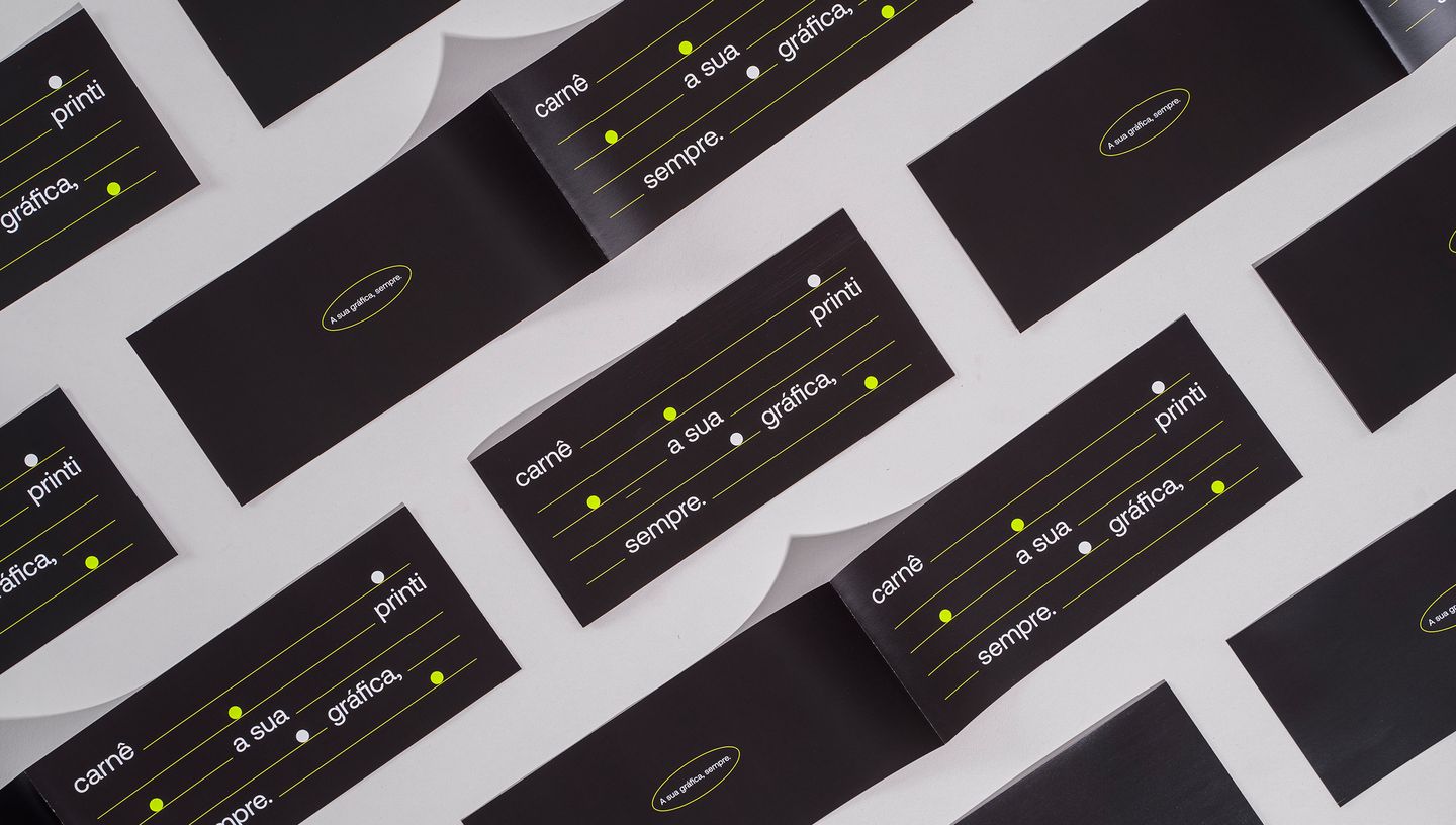 Várias capas de carnê pretas com detalhes gráficos em verde neon dispostas em padrão repetido sobre fundo cinza, com a frase “carnê, a sua gráfica, sempre.” estampada.