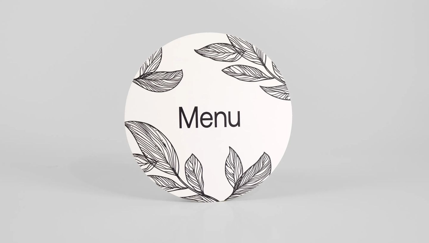 cardápio redondo na cor branca escrito menu e com folhas envolta 