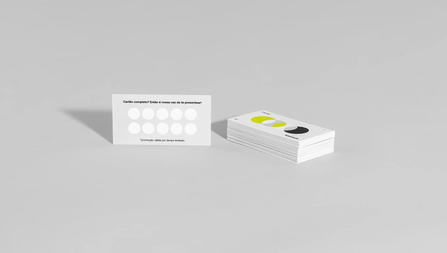 Pilha de cartões fidelidade personalizados brancos com design minimalista e campos de pontuação visíveis.