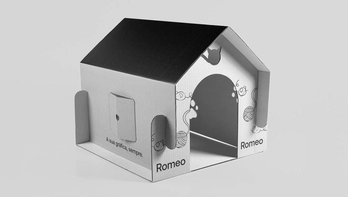 Casinha para gato personalizada em papelão ondulado com telhado preto e nome impresso, ideal como embalagem criativa ou produto promocional para pet shops.