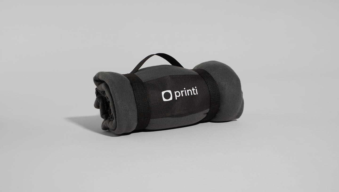 Manta polar e embalagem na cor preta com logo da Printi.