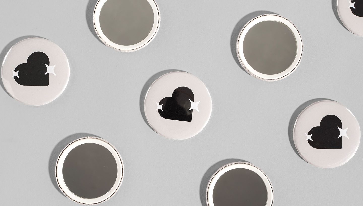 Botton espelho personalizado com desenho de coração na parte da frente.