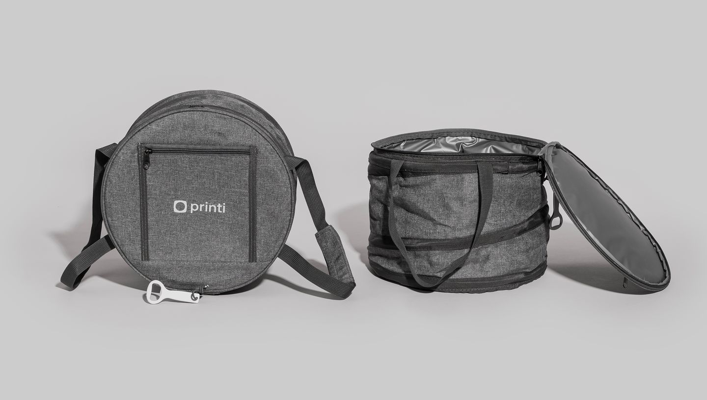 Bolsa térmica flexível redonda na cor cinza mescla, com alça de ombro ajustável e abridor de garrafa branco acoplado.