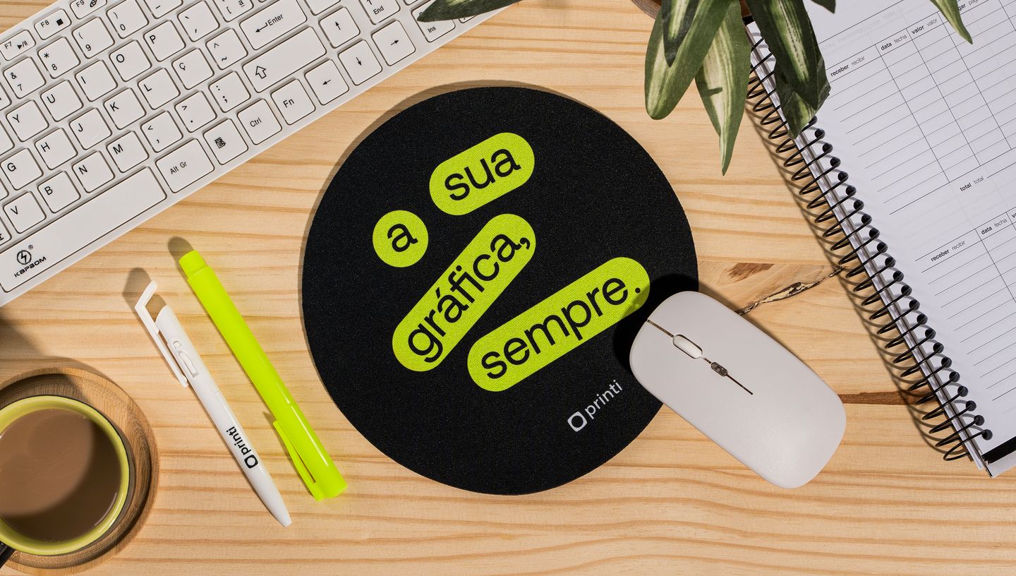 Mouse sobre mouse pad redondo personalizado com slogan da Printi na cor preto e verde.