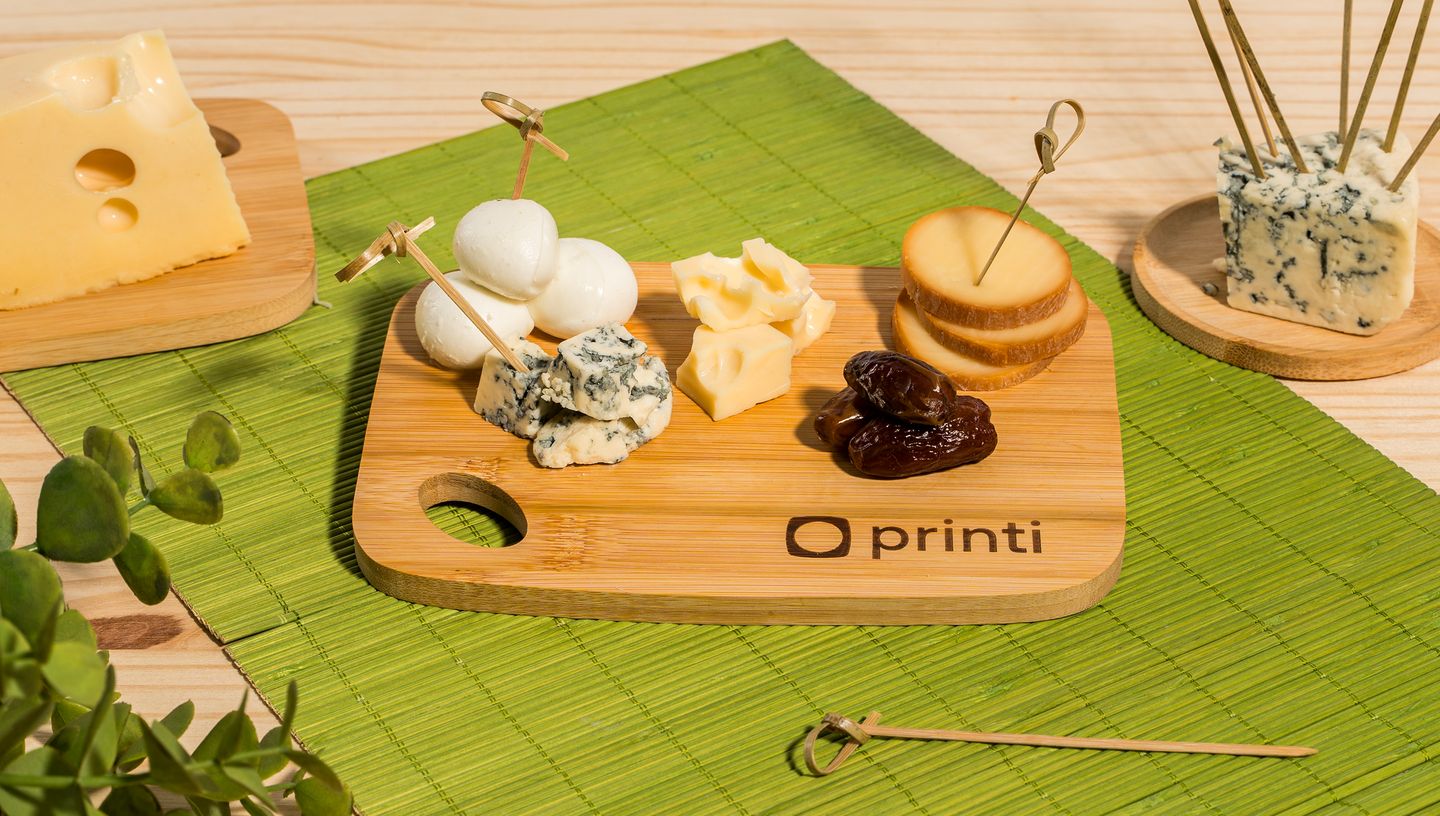 Tábua de bambu personalizada da Printi sendo usada como petisqueira com queijos e frutas secas