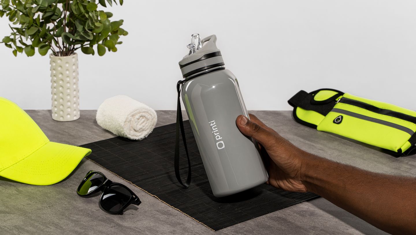 Pessoa segurando squeeze esportivo PETG personalizado na cor branca.