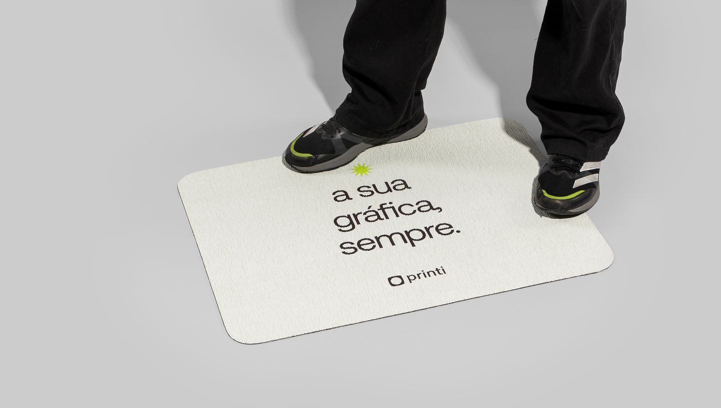 Pessoa pisando em tapete personalizado da Printi com a frase “a sua gráfica, sempre”