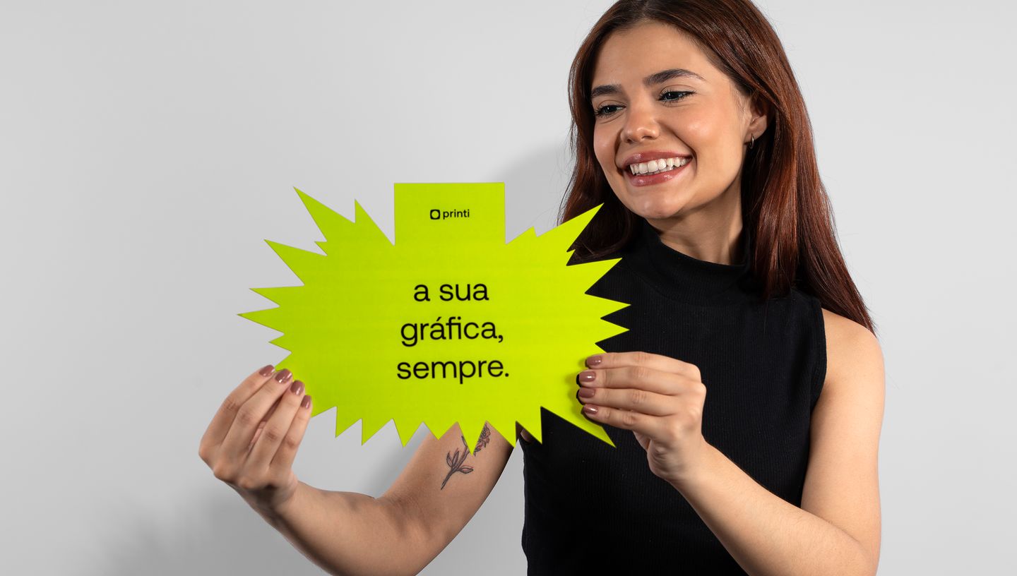 Mulher branca sorrindo segurando Cartão Splash na cor verde com logo e slogam da Printi.