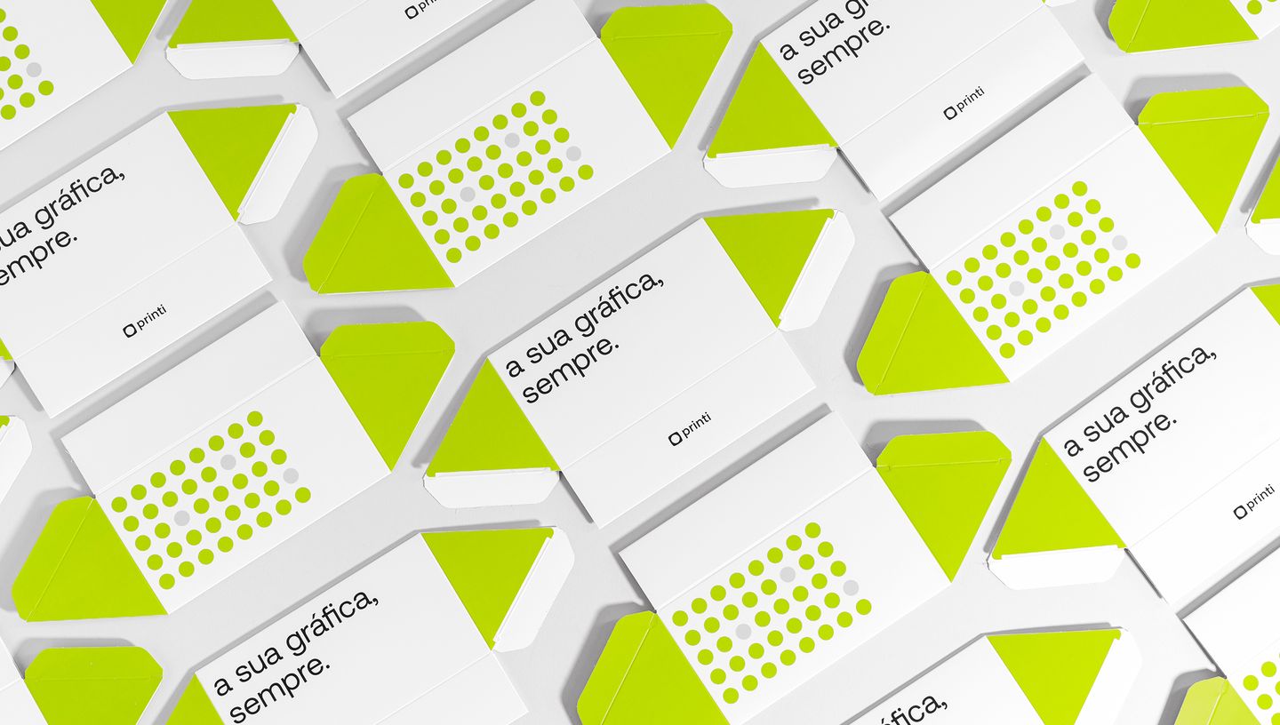 Embalagem triangular desmontada nas cores branco e verde, com slogam da Printi.