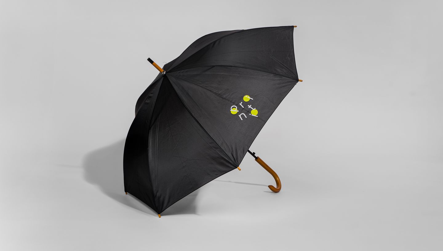 Guarda-chuva preto com cabo de madeira aberto em fundo neutro, com logo personalizada da Printi