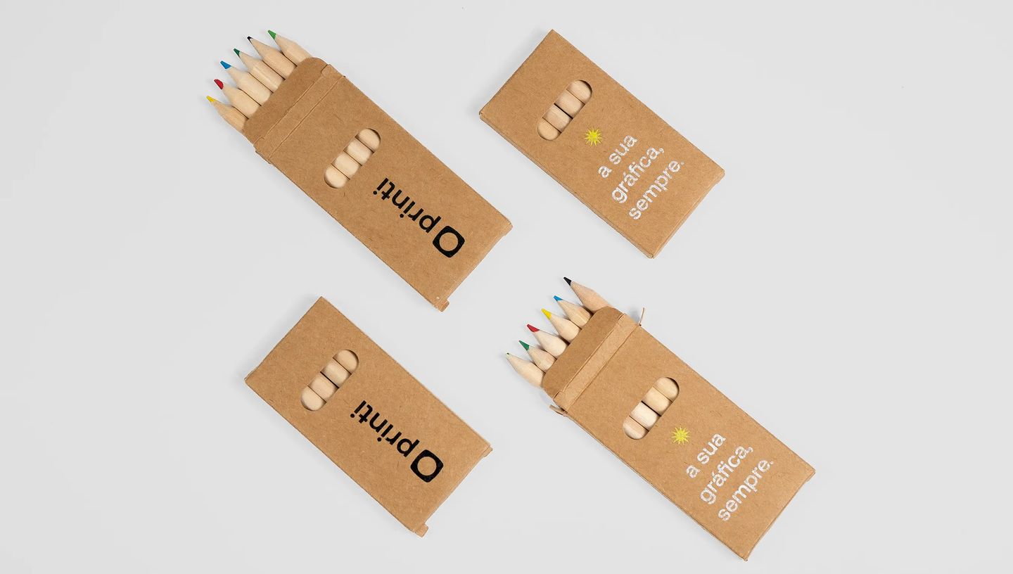 Lápis de cor em embalagem de papel kraft personalizada com logotipo e frase institucional.