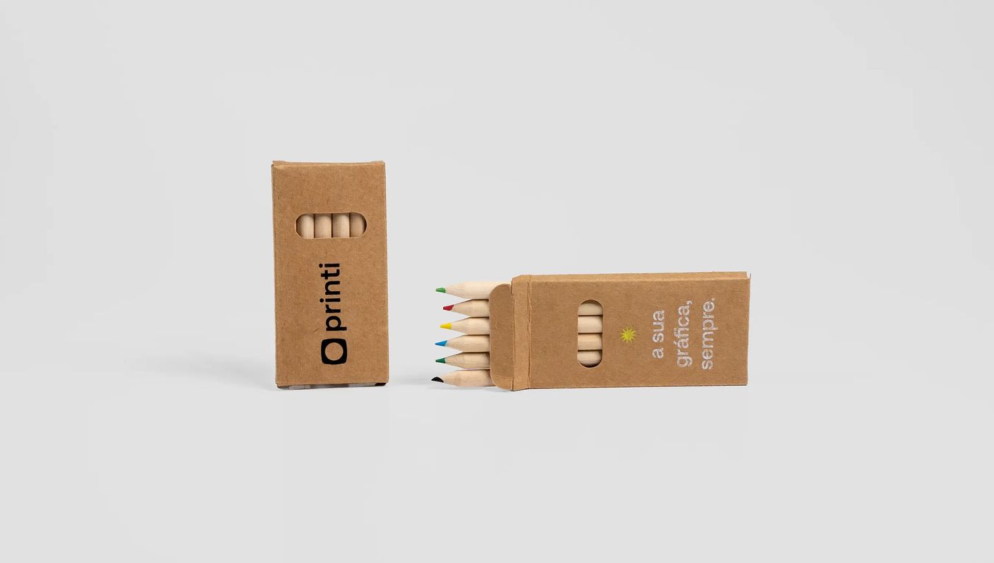 Lápis de cor em caixa de papel kraft personalizada com logotipo e slogan em design sustentável.