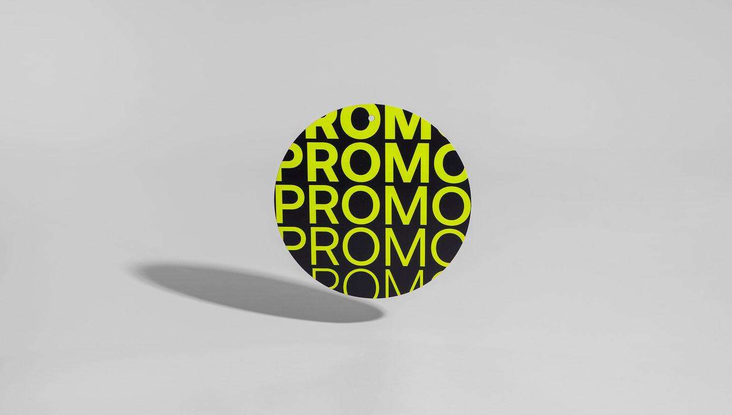 Móbile promocional redondo com estampa repetida da palavra 'PROMO' em verde neon e  sobre fundo neutro