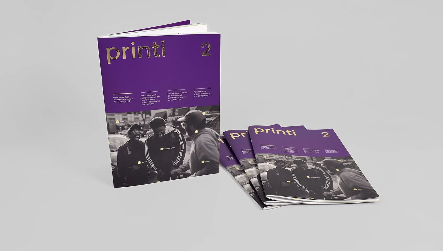 Revista personalizada com capa roxa e detalhes dourados em hot stamping, empilhada sobre fundo neutro.