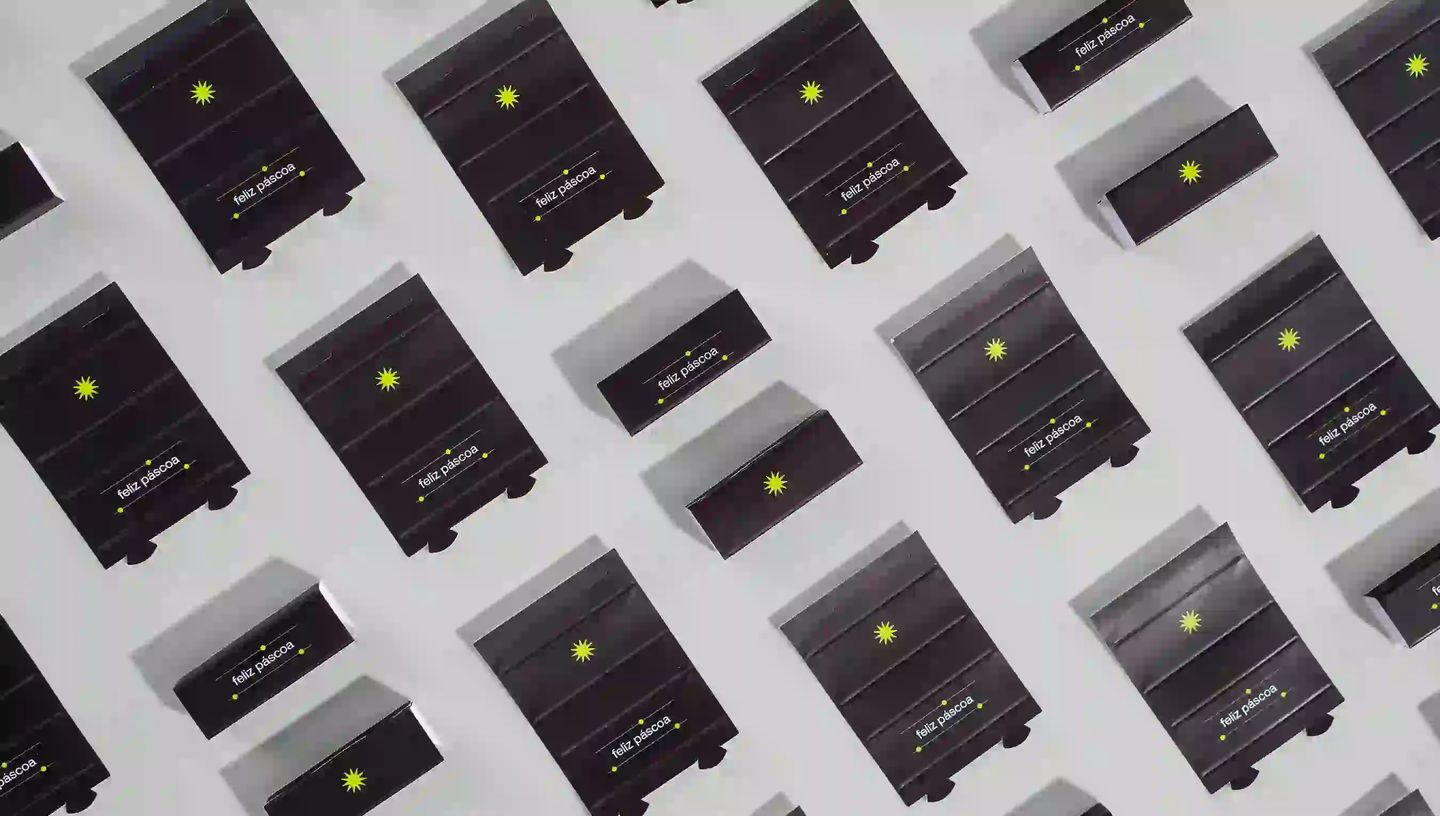Vários rótulos de Bis personalizados com design minimalista preto, detalhes em amarelo neon e a mensagem "feliz páscoa"