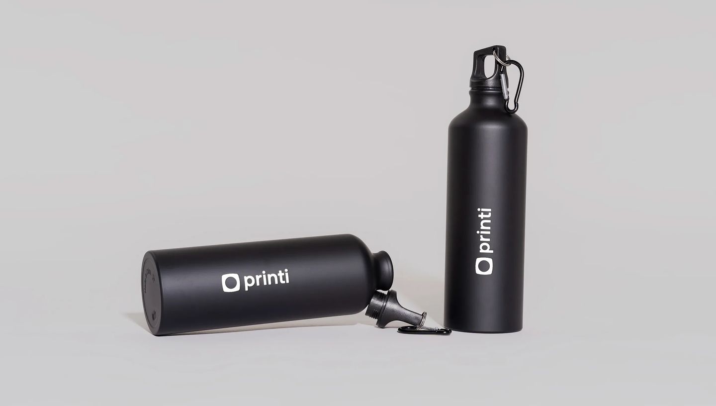 Dois squeezes de metal premium pretos personalizados com logotipo branco em layout minimalista.