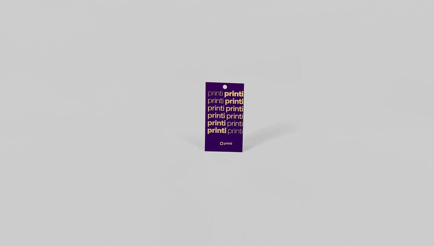 Tag de papel personalizada na cor roxa com logotipo em dourado e acabamento premium.