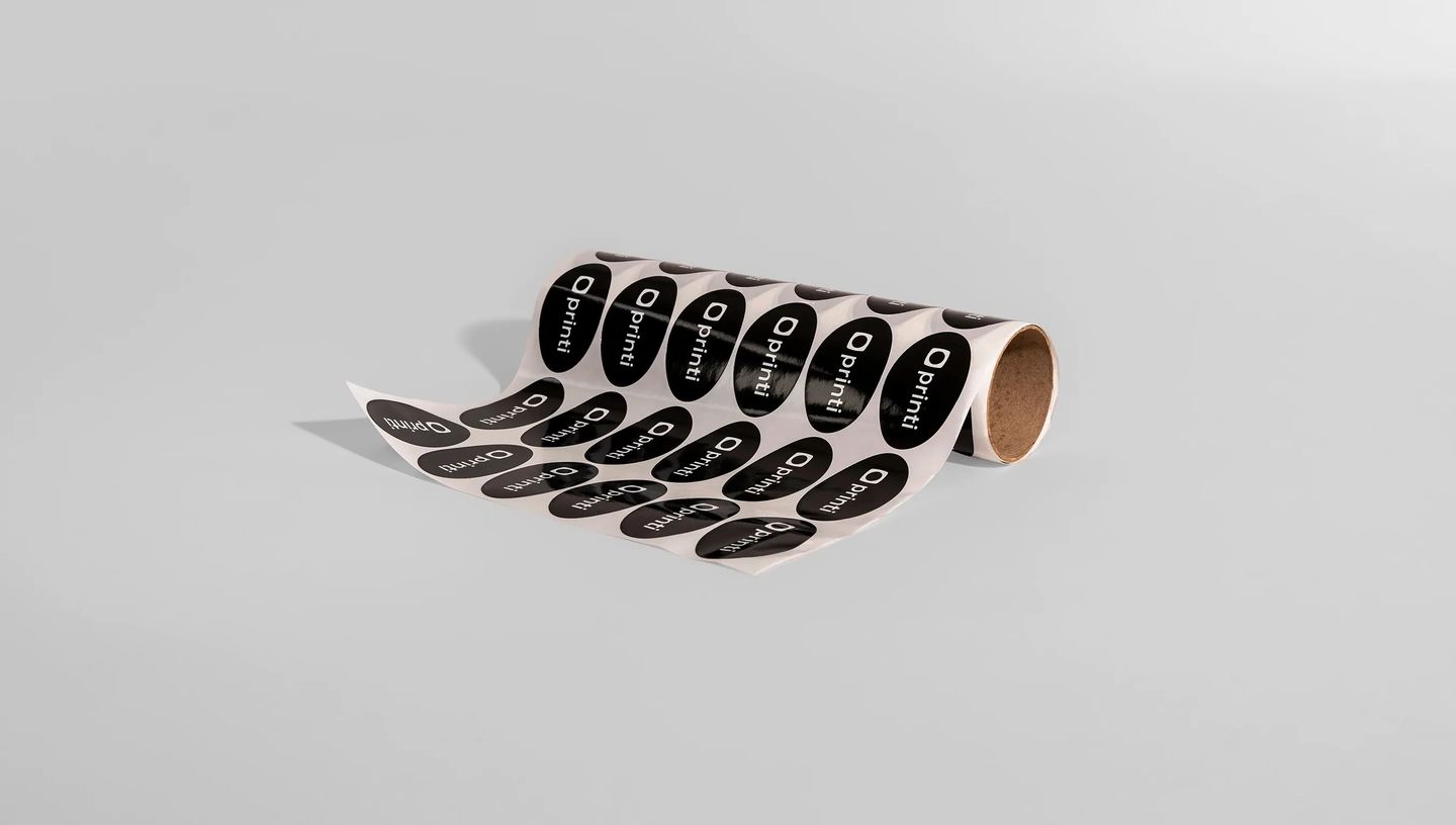Rolo de adesivos ovais personalizados com impressão em preto e branco, ideais para etiquetas de produtos, embalagens e identificação de marca.