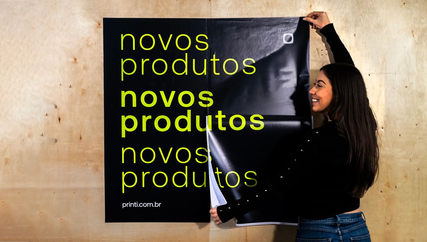 Mulher colocando adesivos grandes personalizados em parede.