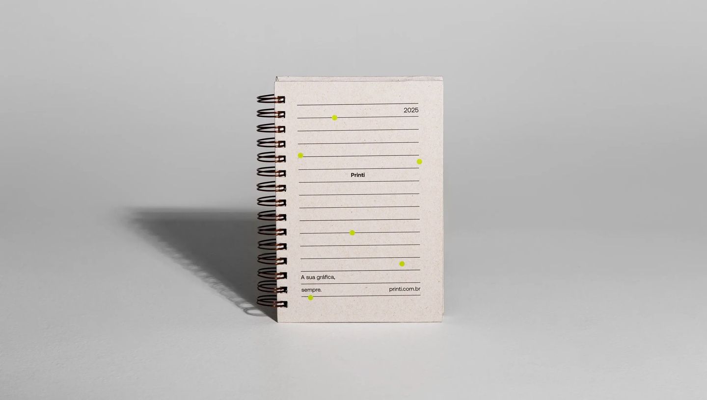 Agenda personalizada com capa em papel reciclado e espiral metálico para o ano de 2026.