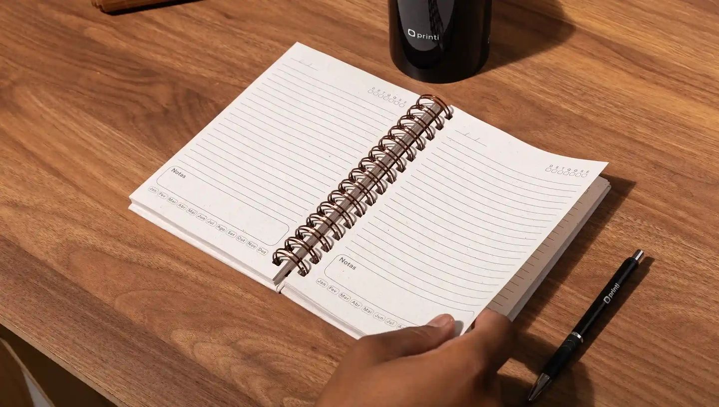 Agenda personalizada aberta sobre mesa de madeira com páginas pautadas para organização de tarefas e anotações.