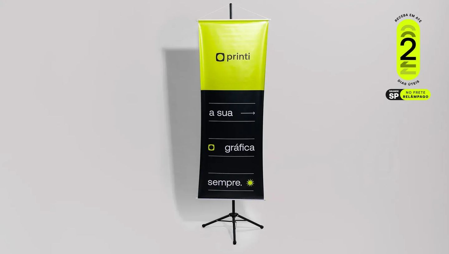 Banner de lona personalizado da Printi montado em suporte tripé preto, destacando o selo de entrega rápida em 2 dias úteis para São Paulo.