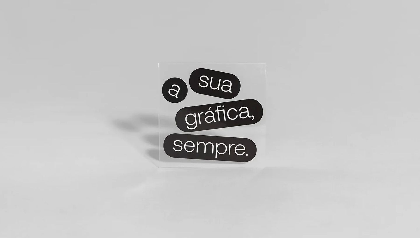 Adesivo transparente personalizado com a frase "A sua gráfica, sempre" em preto e branco, ideal para vitrines e embalagens.