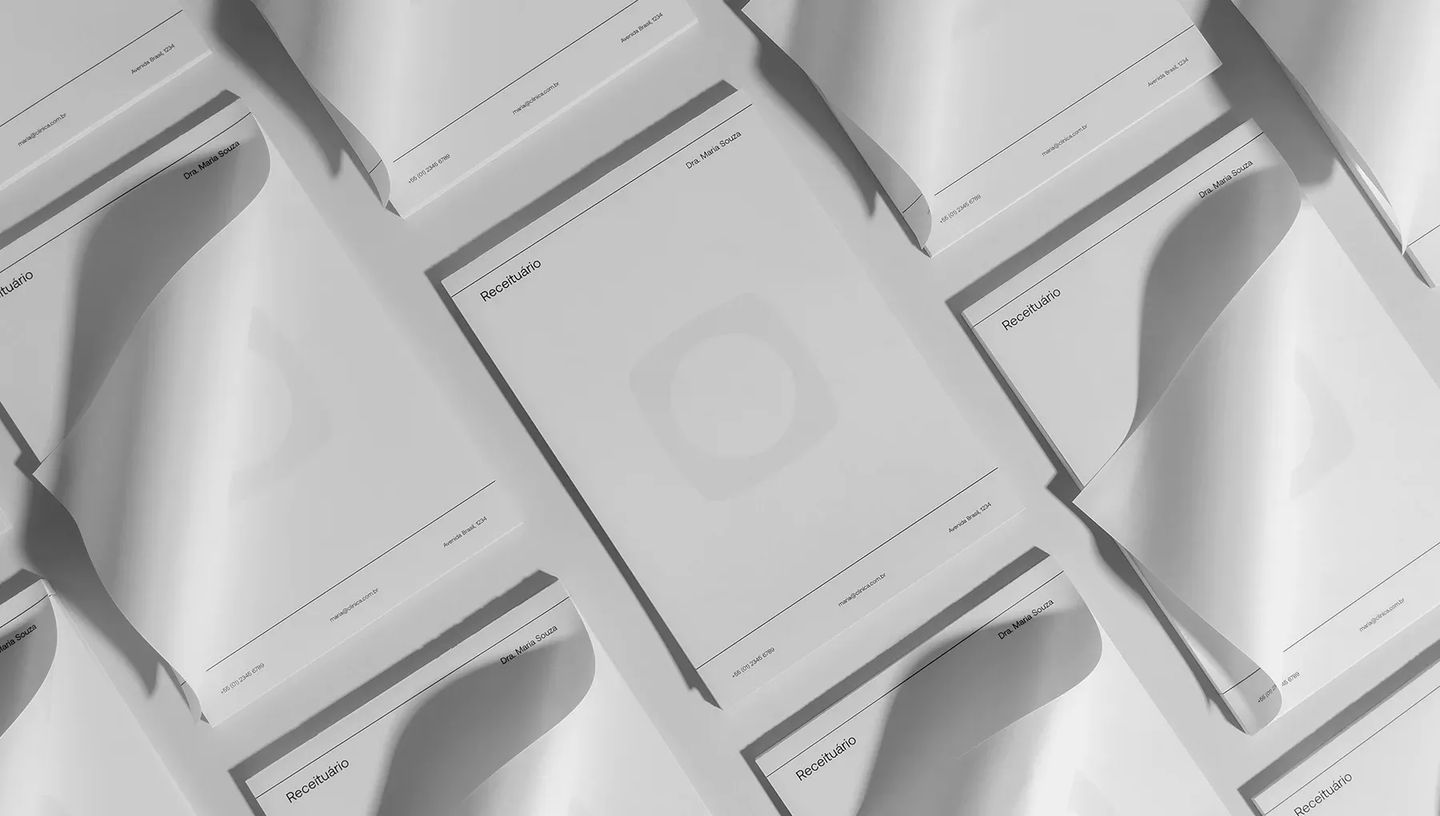 Composição de diversos blocos de notas personalizados espalhados sobre superfície neutra, destacando design clean.