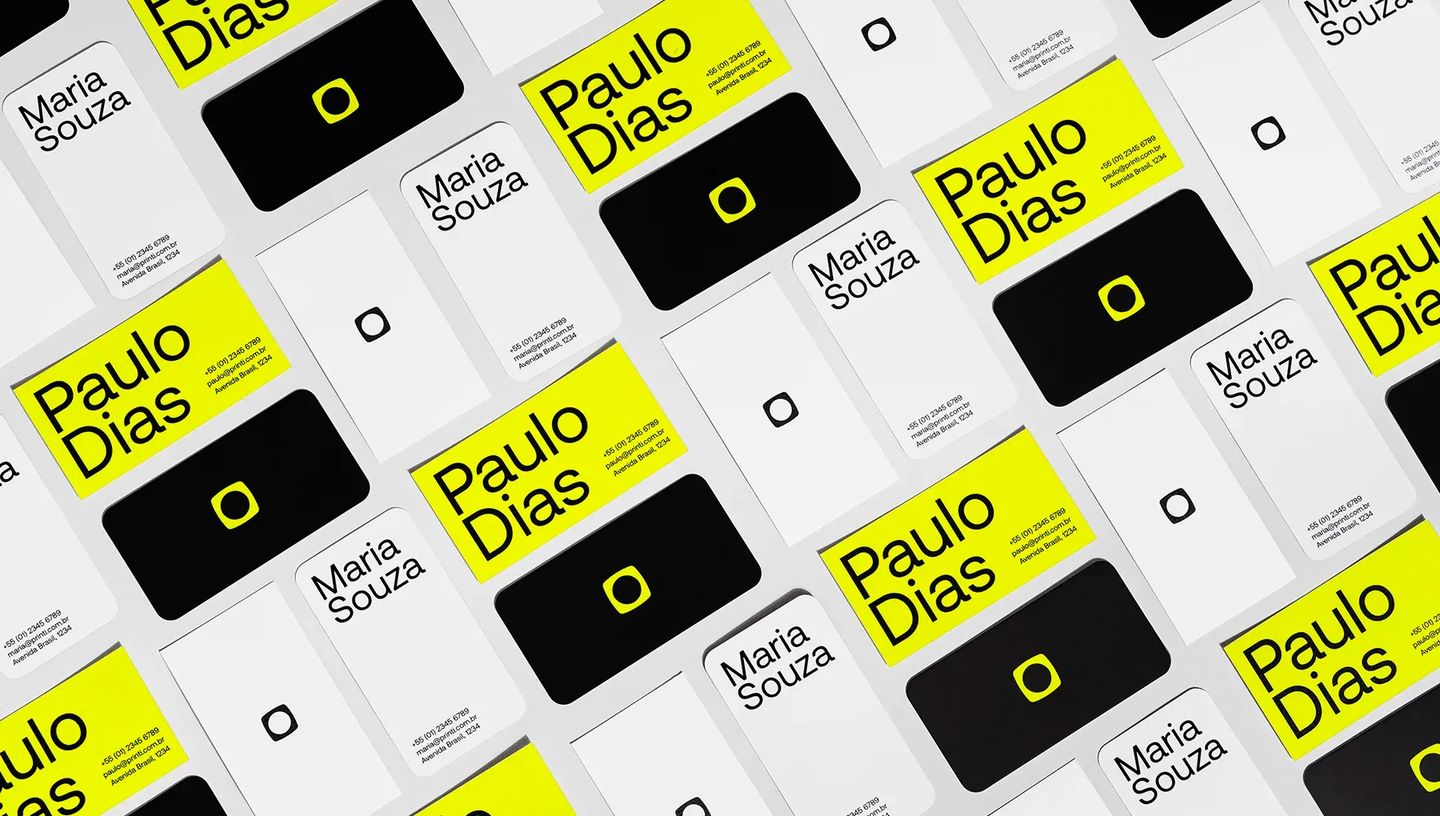Amostras de cartões de visita profissionais em amarelo neon, preto e branco com logotipo da Printi, demonstrando qualidade de impressão gráfica.