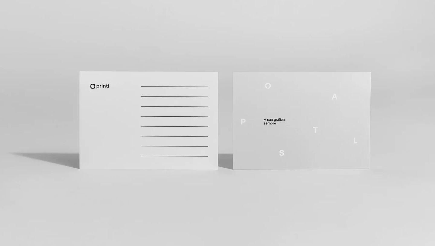 Modelo de cartão postal personalizado da Printi exibindo frente com design minimalista e verso com linhas para endereço e selo.