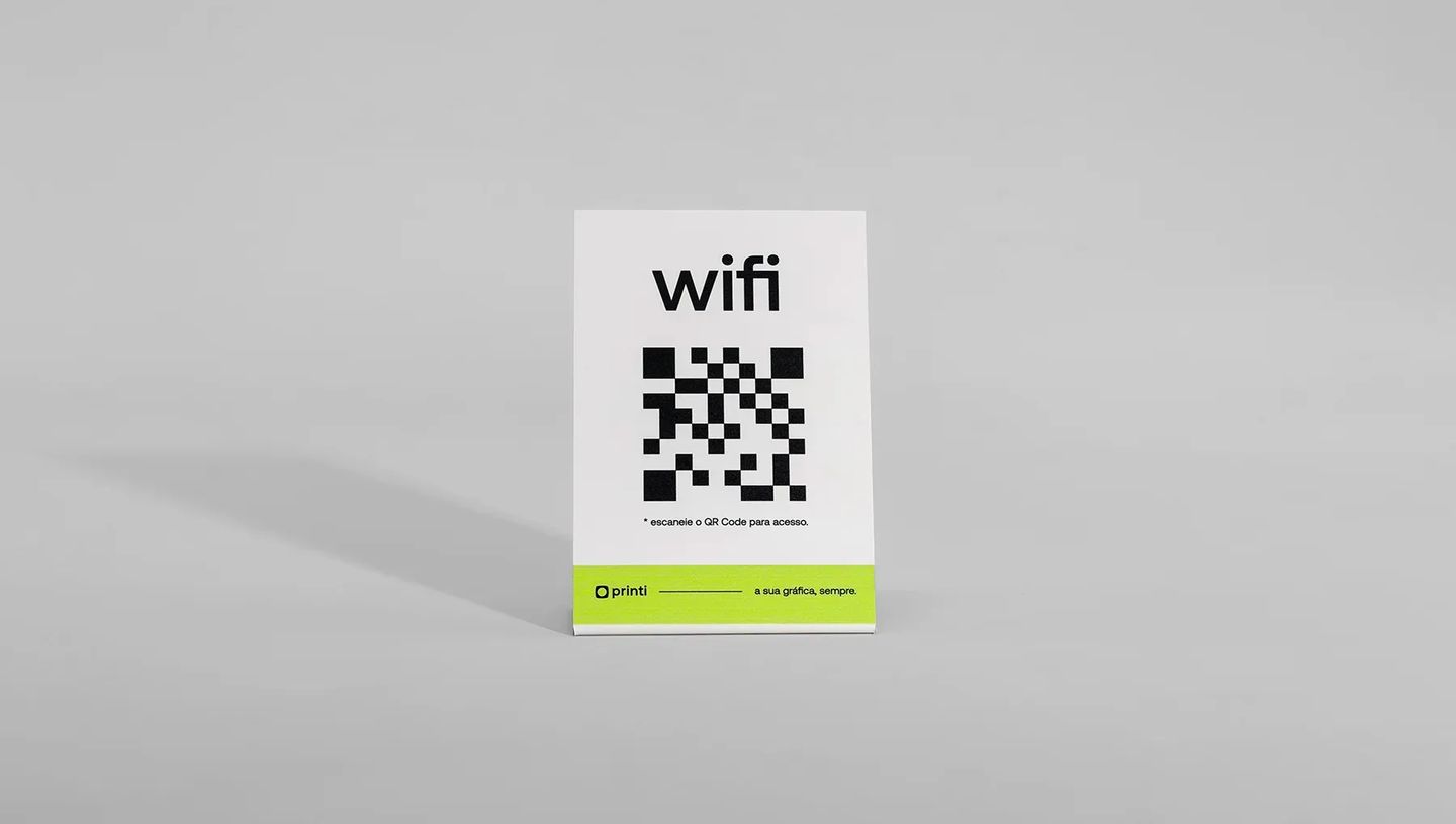 Display em L de mesa feito de papel resistente com impressão de QR Code para Wi-Fi, visto de frente em fundo cinza neutro.