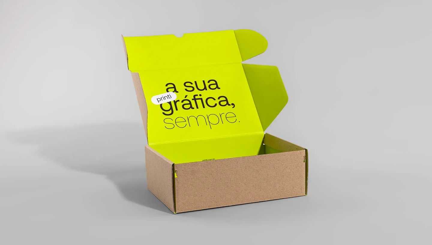 Visão lateral de caixa de papelão kraft para envio aberta com interior personalizado em verde neon, ideal para unboxing experience premium.