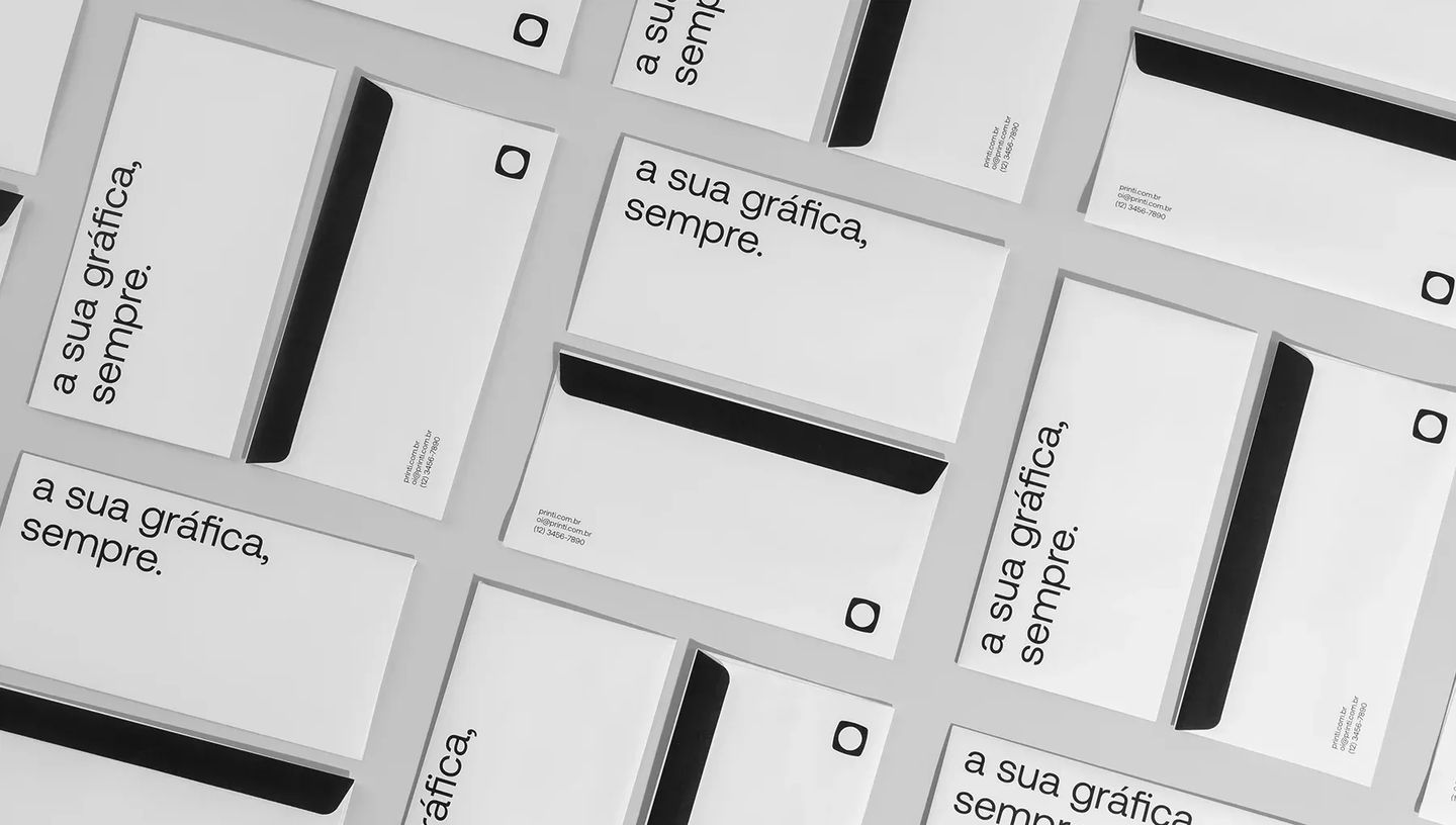 Composição de vários envelopes personalizados da Printi espalhados de forma organizada. As peças brancas exibem o slogan "a sua gráfica, sempre." e detalhes de contato, destacando a padronização de papelaria corporativa.