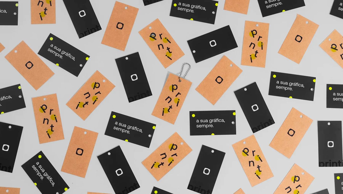 Amostras de tags personalizadas em papel kraft e papel preto com diferentes layouts de impressão, demonstrando variedade de acabamentos gráficos.