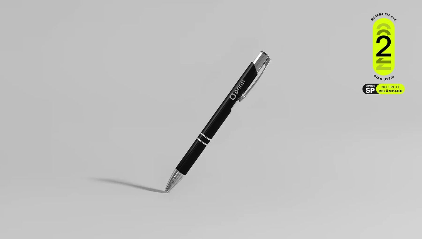 Caneta Metal Classic preta personalizada com o logo da Printi, posicionada na diagonal sobre fundo cinza claro. No canto superior direito, selo promocional verde com a informação de entrega em até 2 dias úteis na Grande São Paulo com frete relâmpago.