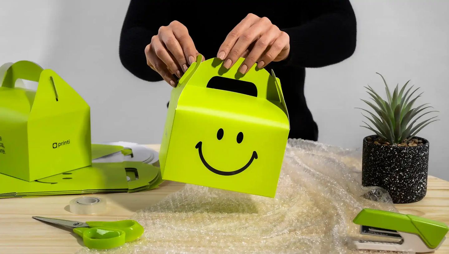 Embalagem personalizada com alça recortada, impressão colorida, em fundo branco e ângulo frontal