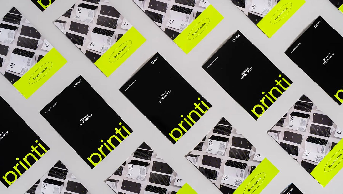 Flyers impressos da Printi com acabamento profissional, exibindo o logotipo da marca e design moderno para divulgação de serviços gráficos.