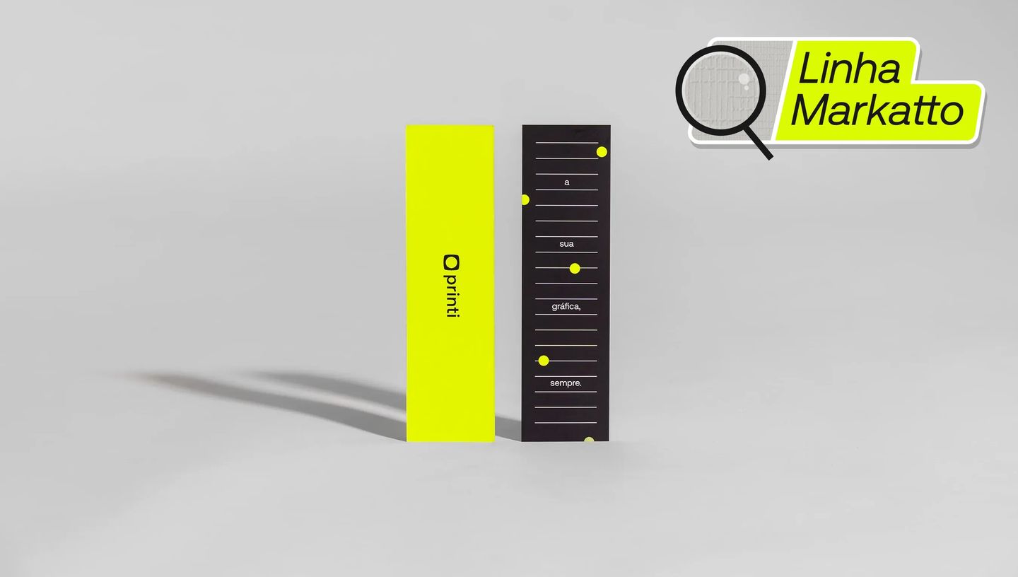 Marcadores de página personalizados da Linha Markatto da Printi em destaque sobre fundo neutro, um em verde neon com logo da marca e outro em preto com linhas e elementos gráficos