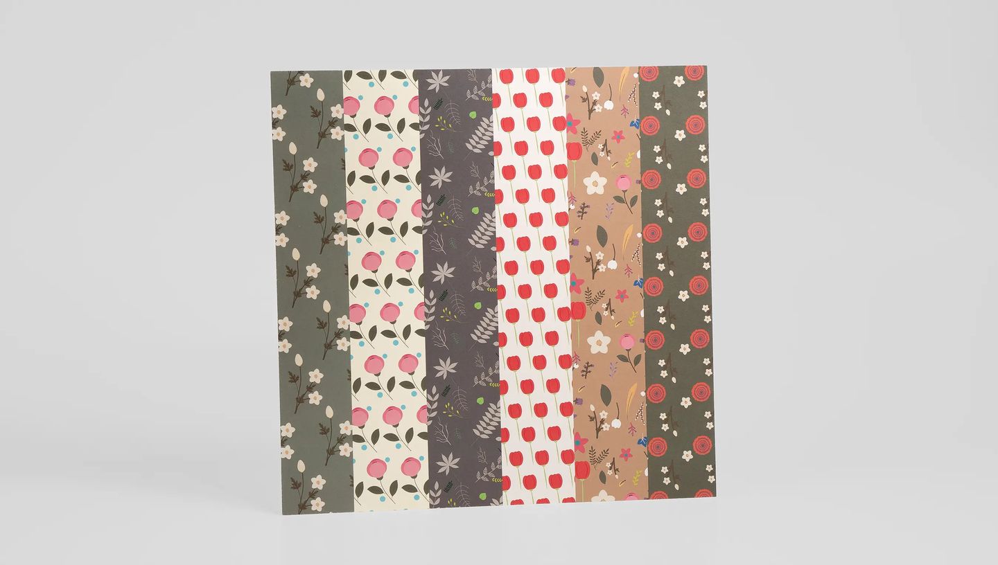 Papel Scrapbook personalizado com seis diferentes padrões florais e botânicos em listras verticais, apresentando cores suaves e layout criativo.