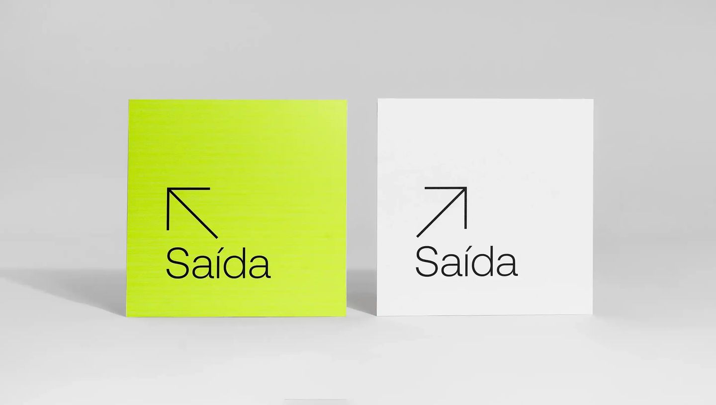 Duas placas de sinalização quadradas para saída, nas cores verde neon e branco, com design minimalista.