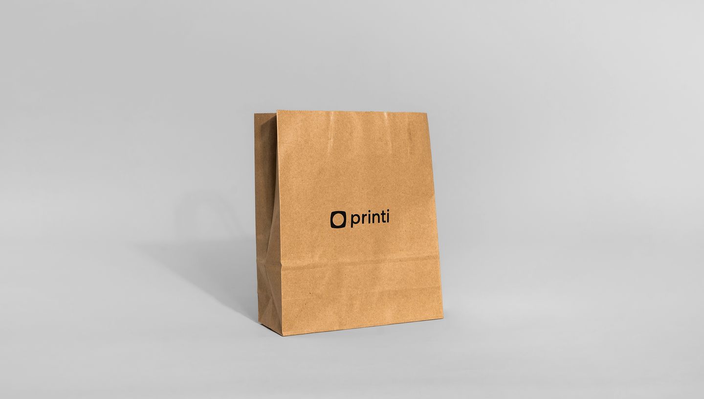  Saco de papel kraft personalizado com a marca Printi, em um fundo branco e liso