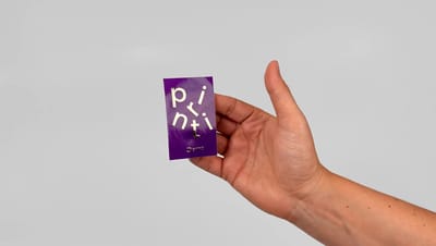 Adesivo retangular personalizado em fundo roxo com letras em relevo, segurado na mão, ideal para identificação de produtos, embalagens e ações promocionais.