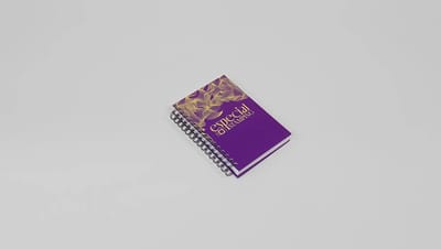 Agenda personalizada com capa roxa em hot stamping dourado e encadernação espiral para organização e planejamento.