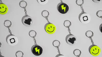 Chaveiros personalizados em formato de botton distribuídos sobre fundo neutro, com designs variados em preto, branco e verde neon, incluindo ícones de sorriso, raio e coração