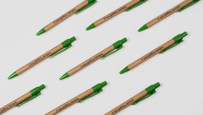 Caneta ecológica personalizada com corpo em papel reciclado e detalhes verdes, ideal para brindes sustentáveis e ações corporativas.