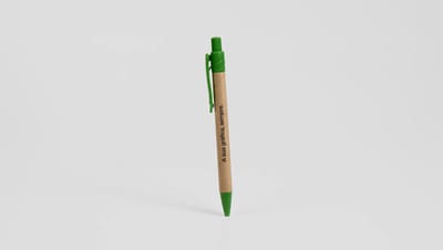 Caneta Eco Masai personalizada em papel craft com detalhes em verde, apresentando a frase 'A sua gráfica, sempre.' em layout sustentável e minimalista.