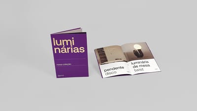 Catálogo personalizado roxo aberto exibindo fotos de luminárias e acabamento em hot stamping dourado.